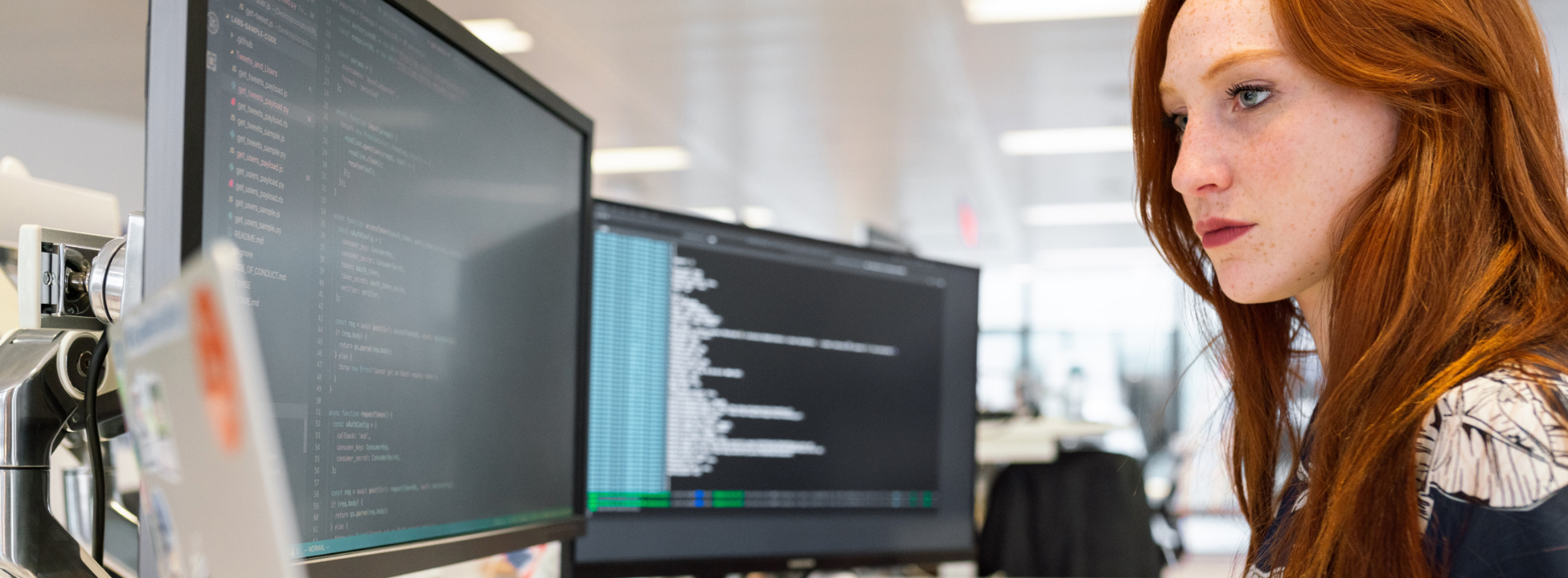 Woman looking at her desktop monitors.