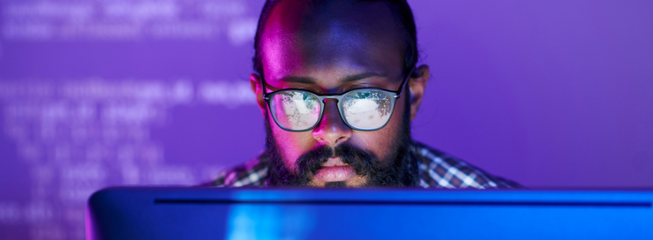 Man looking at information on a computer monitor.