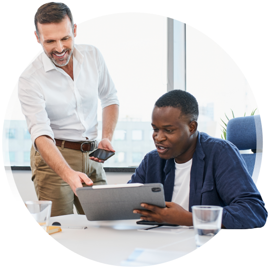 two people in an office looking at a tablet